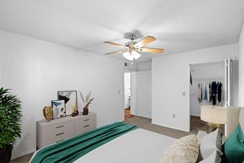 a bedroom with a large bed and a ceiling fanat Stonebriar Apartments, Overland Park